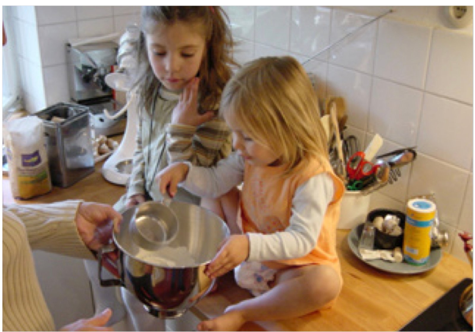 A mother and two children baking together in a home kitchen